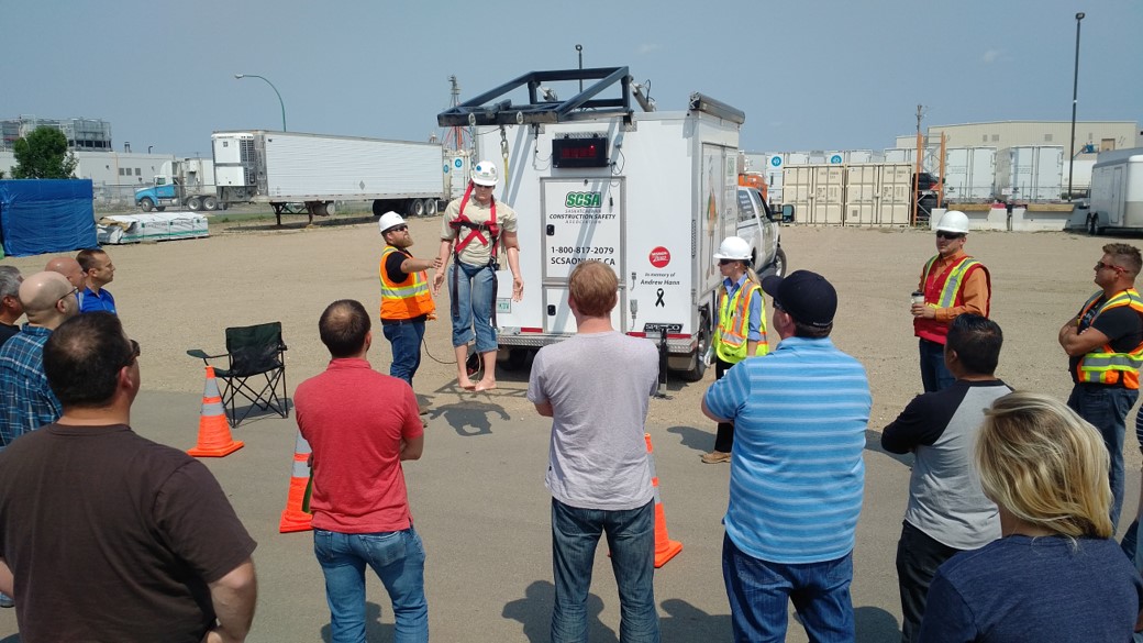  Dynamo employees surround safety instructor as they learn about fall arrest equipment in Saskatoon, Saskatchewan. 