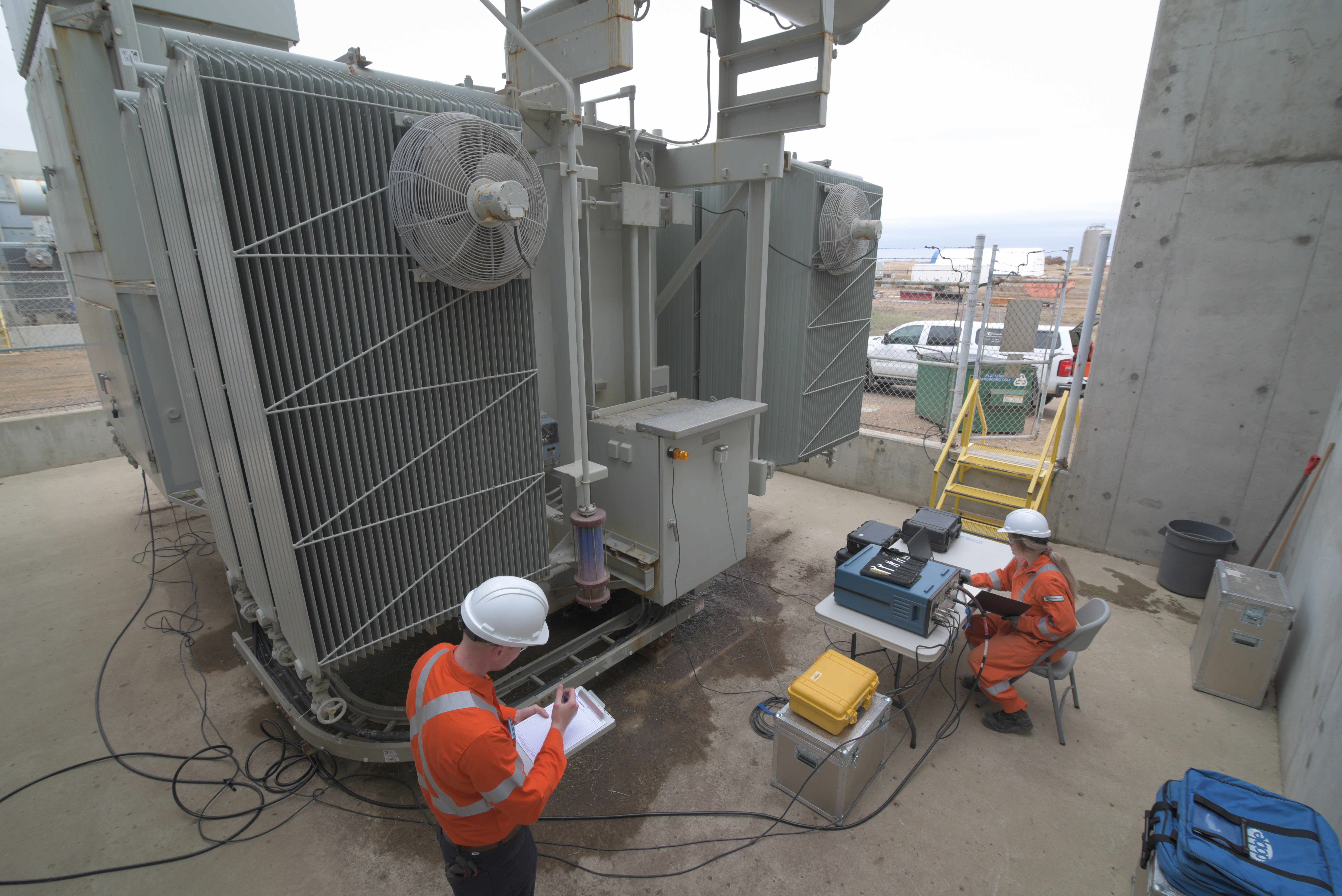 Dynamo employees using diagnostic instrumentation hooked up to larg transformer to run diagnostic check before performing a shutdown.